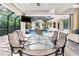 Outdoor dining area with glass table and chairs, view of pool at 1810 Wisteria St, Sarasota, FL 34239