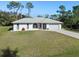 Single-story home with gray roof and white exterior, featuring a large yard at 18314 Koala Ave, Port Charlotte, FL 33948