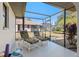 Relaxing screened porch with lounge chairs, overlooking backyard at 18314 Koala Ave, Port Charlotte, FL 33948