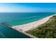 Aerial showcasing beach, ocean, and jetty at 20289 Benissimo Dr, Venice, FL 34293