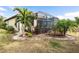 Landscaped backyard with a large screened patio at 20289 Benissimo Dr, Venice, FL 34293