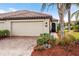 Beige home exterior with two-car garage and walkway at 20289 Benissimo Dr, Venice, FL 34293