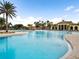 Community pool with expansive deck and luxurious clubhouse in background at 20289 Benissimo Dr, Venice, FL 34293