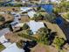 Aerial view of a single-story house on a canal, with lush green surroundings at 207 Waterway Ne Cir, Port Charlotte, FL 33952