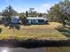 An aerial view of a canal-front property with a single-story house and shed at 207 Waterway Ne Cir, Port Charlotte, FL 33952