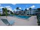 Community pool with lounge chairs and palm trees at 2075 Canal Dr # L36, Bradenton, FL 34207