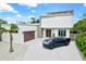 Contemporary home with attached garage, showcasing a sleek design and landscaping at 2138 Floyd St, Sarasota, FL 34239