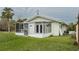 Back of house featuring a screened porch and grassy yard at 29 Mound, Terra Ceia, FL 34250