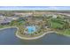 Aerial view of resort style community with community pool, tennis court, lush landscape and lake at 328 Aria Dr, Nokomis, FL 34275