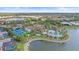 Aerial view of community amenities with a tennis court, pool, spa, and lake at 328 Aria Dr, Nokomis, FL 34275