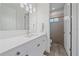 Bright bathroom vanity with modern lighting, sleek countertop, and glass shower in background at 328 Aria Dr, Nokomis, FL 34275