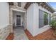 Inviting front entrance with stone accents, a gray front door, and gray shutters on a bright window at 328 Aria Dr, Nokomis, FL 34275