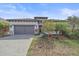 Charming single-story home featuring a paved driveway, gray garage door, and well-manicured landscaping at 328 Aria Dr, Nokomis, FL 34275