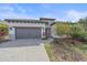 Charming single-story home featuring a paved driveway, gray garage door, and well-manicured landscaping at 328 Aria Dr, Nokomis, FL 34275