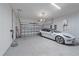 Garage with a Tesla car and charger with an epoxy floor, and plenty of storage space at 328 Aria Dr, Nokomis, FL 34275