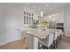 Bright kitchen featuring a center island with seating, modern appliances, and white cabinetry with glass fronts at 328 Aria Dr, Nokomis, FL 34275