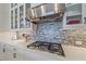 Gourmet kitchen featuring stainless steel range hood, quartz countertops, and glass-front cabinets for storage at 328 Aria Dr, Nokomis, FL 34275