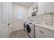 Well-lit laundry room with modern washer and dryer, storage cabinets, and a utility sink at 328 Aria Dr, Nokomis, FL 34275