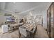 Open concept living room with hardwood floors, a modern chandelier, piano, and seamless flow into the kitchen at 328 Aria Dr, Nokomis, FL 34275