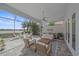 Screened-in outdoor living space featuring patio furniture, a ceiling fan, and lush landscaping at 328 Aria Dr, Nokomis, FL 34275