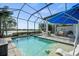 Resort-style pool and spa with covered patio, outdoor kitchen, and lake view at 328 Aria Dr, Nokomis, FL 34275