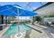 Resort-style pool with patio furniture and a blue umbrella at 328 Aria Dr, Nokomis, FL 34275