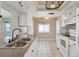 Kitchen with white cabinets, dual sink, and tiled floor at 3608 Joyce Dr, Bradenton, FL 34208