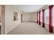 Bright living room with neutral walls and carpeting, featuring a door and large windows at 3608 Joyce Dr, Bradenton, FL 34208