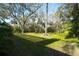 Landscaped backyard with mature trees and grassy area at 3709 Wilderness W Blvd, Parrish, FL 34219