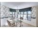 Bright dining area with glass table and chairs, featuring a floral wallpaper at 3709 Wilderness W Blvd, Parrish, FL 34219