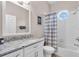 Clean bathroom with granite vanity, white cabinets, and striped shower curtain at 3832 5Th Ne Ave, Bradenton, FL 34208