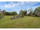 Landscaped backyard featuring lush lawn and mature trees at 395 W Rossetti Dr, Nokomis, FL 34275