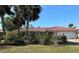 Front view of a charming single-story home with a red tile roof and landscaped yard at 395 W Rossetti Dr, Nokomis, FL 34275