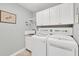 Laundry room with white cabinets and a modern washer and dryer at 395 W Rossetti Dr, Nokomis, FL 34275