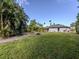 Large grassy yard with mature palm trees and landscaping at 4584 Country Manor Dr, Sarasota, FL 34233