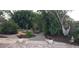 Landscaped backyard with brick pathway, hammock, and lush tropical plants at 4584 Country Manor Dr, Sarasota, FL 34233