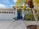 Welcoming front entry with teal door and landscape at 4584 Country Manor Dr, Sarasota, FL 34233