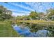 Community canal view with lush landscaping and reflection of homes at 4655 Pine Green Trl # 24, Sarasota, FL 34241