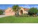 Tan house with tile roof, two-car garage, and tropical landscaping at 4881 Flagstone Dr, Sarasota, FL 34238