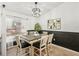 Dining room with a farmhouse table, black and white wainscoting, and light floors at 510 45Th E St, Bradenton, FL 34208