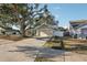 House exterior, featuring a light green color, metal roof, and a large tree in the front yard at 510 45Th E St, Bradenton, FL 34208