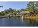 Clubhouse with an array of golf carts and manicured landscape, with pond and fountain at 5432 Hampstead Heath # 26, Sarasota, FL 34235