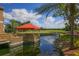 Picturesque gazebo over the water surrounded by green landscaping and a golf course beyond at 5432 Hampstead Heath # 26, Sarasota, FL 34235