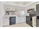 White kitchen with black appliances and wood countertops at 5432 Hampstead Heath # 26, Sarasota, FL 34235