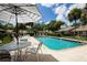 Community pool with lounge chairs and patio tables at 5432 Hampstead Heath # 26, Sarasota, FL 34235