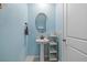 Small powder room with pedestal sink, oval mirror, and light blue walls at 5546 Appleton Shore Dr, Apollo Beach, FL 33572