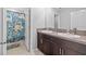 Bathroom with double sinks and dinosaur shower curtain at 5546 Appleton Shore Dr, Apollo Beach, FL 33572