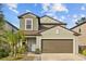 Two-story house with neutral siding, brown garage door, and landscaping at 5546 Appleton Shore Dr, Apollo Beach, FL 33572