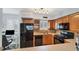 Modern kitchen with wood cabinets, black appliances, and granite countertops at 5671 Ashton Lake Dr # 3, Sarasota, FL 34231