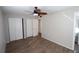 Bright bedroom with ceiling fan, wood-look floors, and ample closet space at 5893 Welcome Rd # I-7, Bradenton, FL 34207